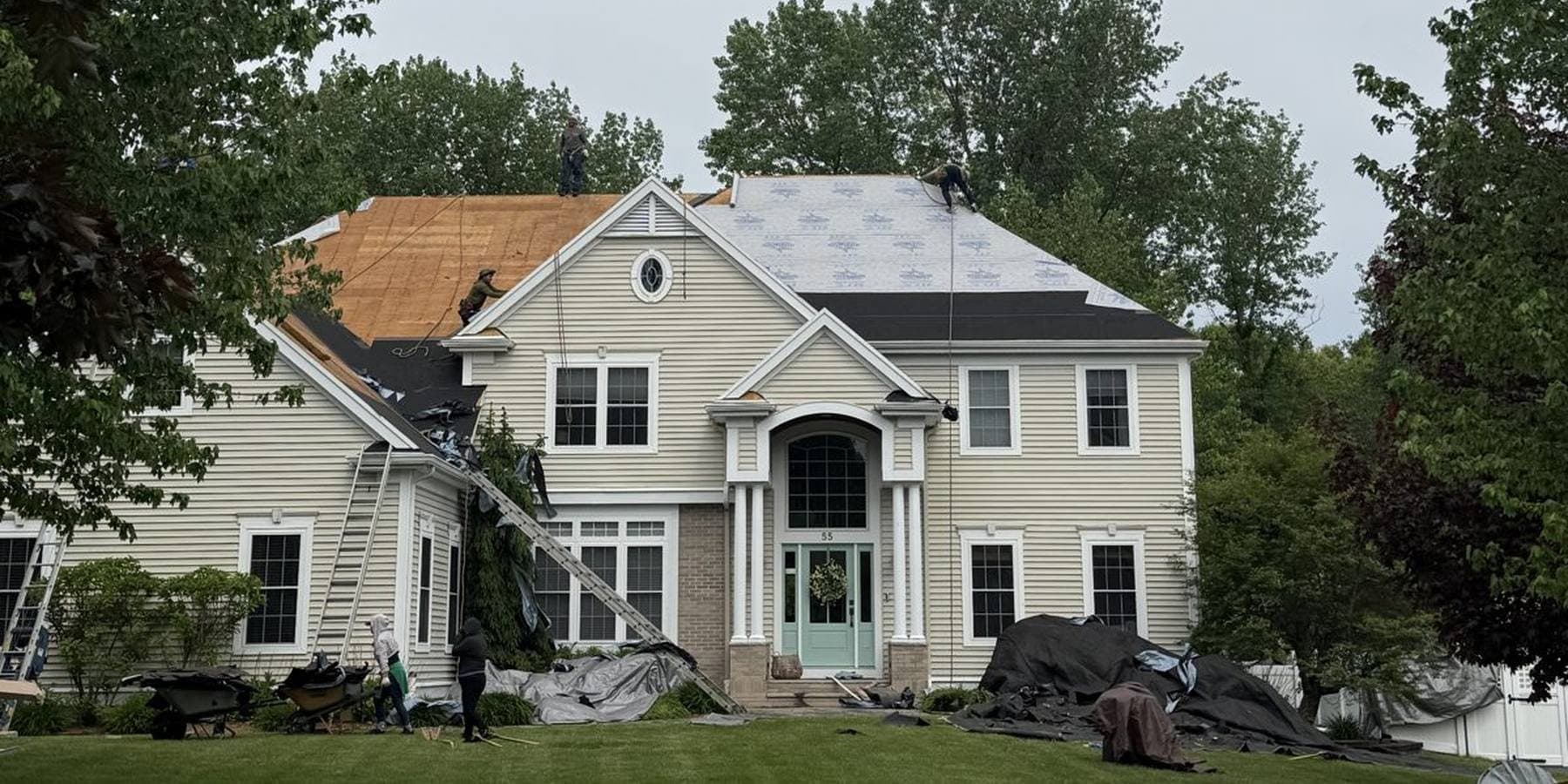 The Rocco's Roofing crew replacing the roof on a large New England colonial