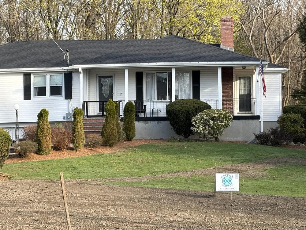 Finished roof with a Rocco's Roofing lawn sign